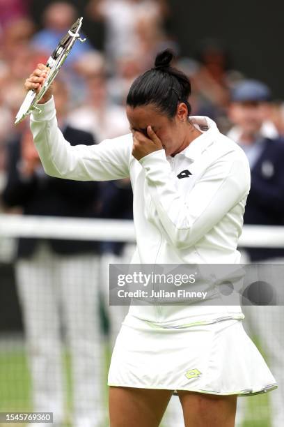 Ons Jabeur of Tunisia looks dejected as she lifts the Women's Singles Runners Up Trophy following defeat in the Women's Singles Final against Marketa...