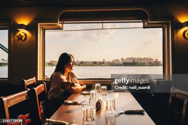 portrait of happy woman who travels on a boat during sunset. - nile river stock pictures, royalty-free photos & images