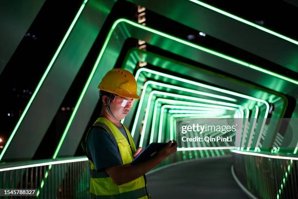 engineers wear smart glasses and use tablets to adjust the lights - safety pin stockfoto's en -beelden