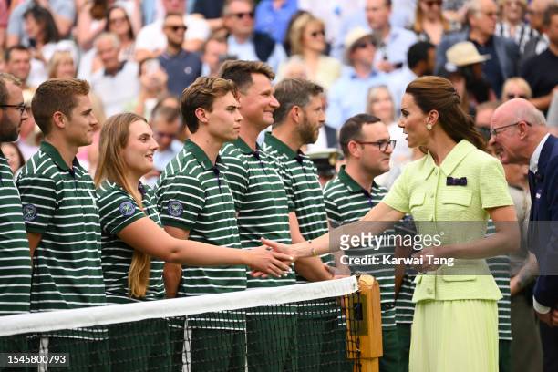 Catherine, Duchess of Cambridge shakes hands with Wimbledon Employees on day thirteen of the Wimbledon Tennis Championships at All England Lawn...