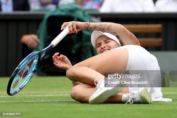 Marketa Vondrousova of Czech Republic falls to the floor as she celebrates winning match point in the Women's Singles Final against Ons Jabeur of...