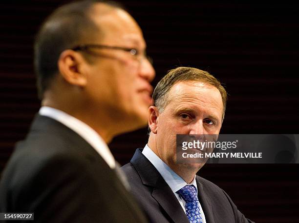 New Zealand Prime Minister John Key watches as Philippine President Benigno Aquino speaks to the media during a joint press conference after their...