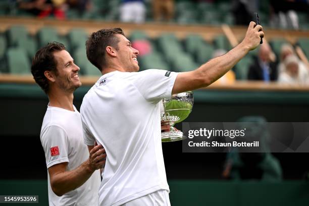 Wesley Koolhof of the Netherlands and Neal Skupski of Great Britain take a selfie with their Men's Doubles Trophies following their victory in the...