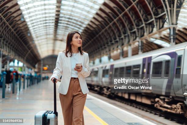 young business woman with luggage walking on the platform at train station - walker stock pictures, royalty-free photos & images
