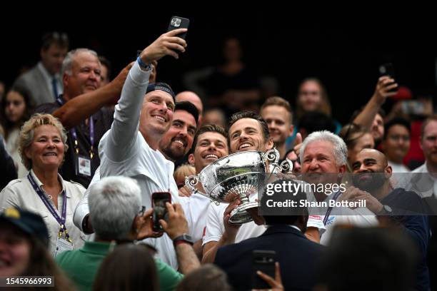 Wesley Koolhof of the Netherlands and Neal Skupski of Great Britain take a selfie with their coaches and Men's Doubles Trophies following their...