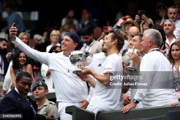 Wesley Koolhof of the Netherlands and Neal Skupski of Great Britain take a selfie with their coaches and Men's Doubles Trophies following their...