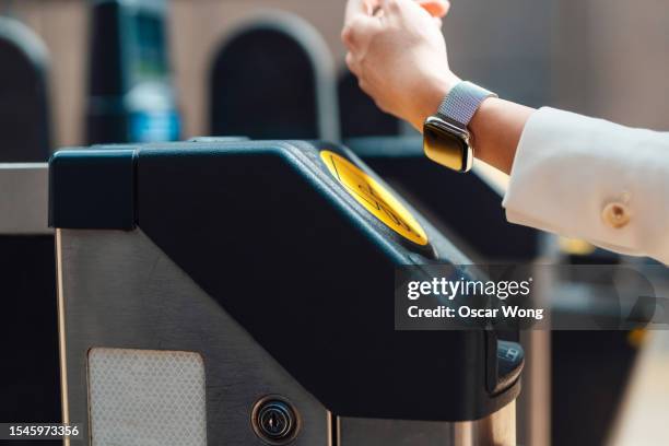 commuter making contactless payment with smart watch at the gate in train station - watch stock pictures, royalty-free photos & images