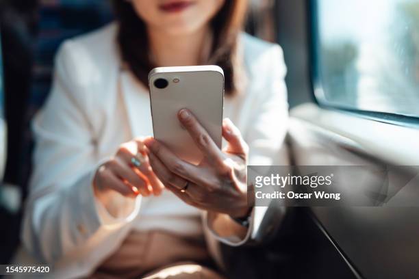 midsection of young business woman using smartphone on train - vehilcles stock pictures, royalty-free photos & images