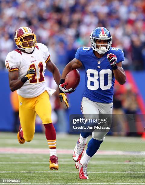 Victor Cruz of the New York Giants runs in a touchdown reception late in the fourth quarter against Madieu Williams of the Washington Redskins at...