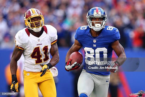 Victor Cruz of the New York Giants runs in a touchdown reception late in the fourth quarter against Madieu Williams of the Washington Redskins at...