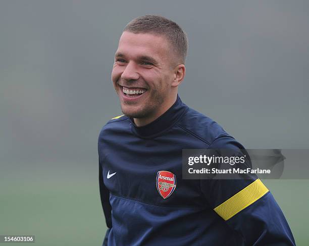 Lukas Podolski of Arsenal smiles during a training session ahead of their UEFA Champions League group stage match against Schalke 04 at London Colney...