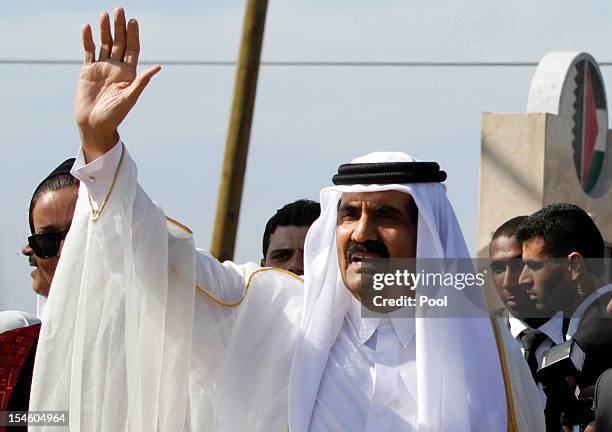 The Emir of Qatar Sheikh Hamad bin Khalifa al-Thani waves to the crowd as they arrive to a cornerstone-laying ceremony of a Qatari funded...
