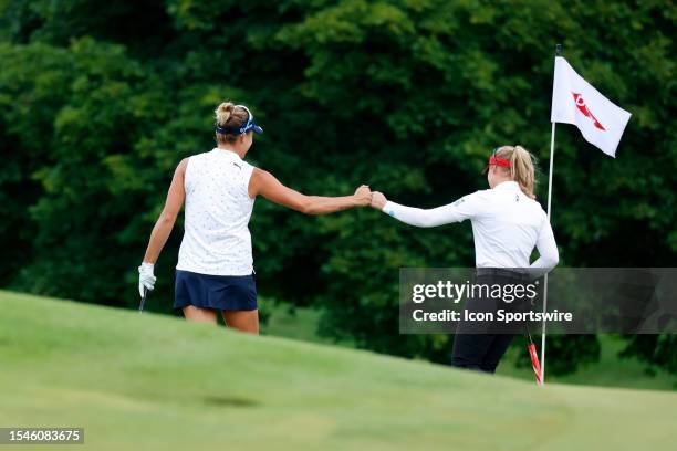 Golfers Lexi Thompson and Brooke Henderson react with a fist bump after making birdie on the 7th hole on July 20 during the second round of the Dow...