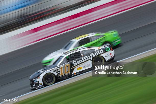 Aric Almirola, driver of the Smithfield Ford, and AJ Allmendinger, driver of the Nutrien Ag Solutions Chevrolet, drive during qualifying for the...