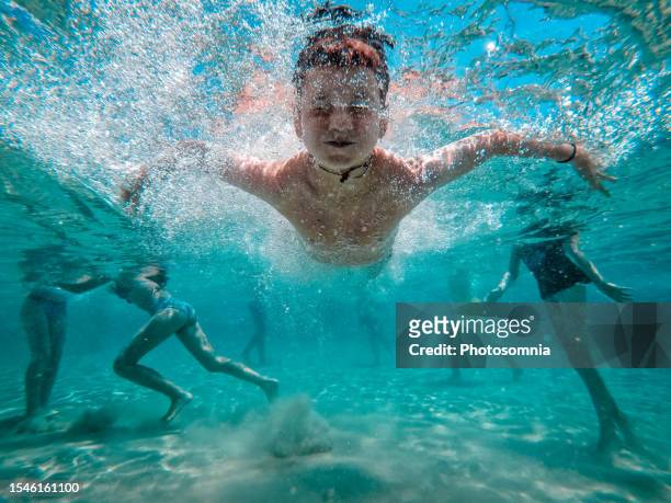 child jumps underwater in the blue sea - water glide stock pictures, royalty-free photos & images
