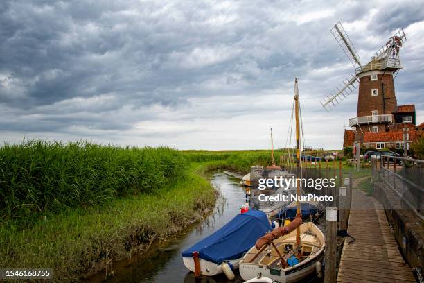 General view of boats moored at the quay near to Cley Windmill, at Cley next the Sea, Holt, Norfolk in England on Tuesday 18th July 2023.