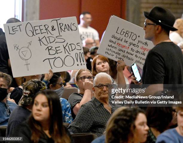 People hold up signs in support of gay and transgender student rights during the Chino Valley Unified School District board meeting at Don Lugo High...