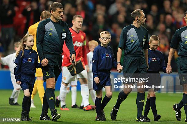 Mascots wearing Unite against Racism T-shirts walk out with the Match Officials prior to the UEFA Champions League Group H match between Manchester...
