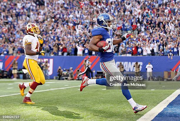 Victor Cruz of the New York Giants runs in a touchdown reception late in the fourth quarter against Madieu Williams of the Washington Redskins at...