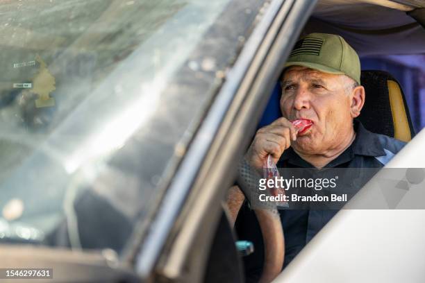 Manuel Solarez eats a popsicle in his car during a heat wave on July 15, 2023 in Phoenix, Arizona. Weather forecasts today are expecting temperatures...