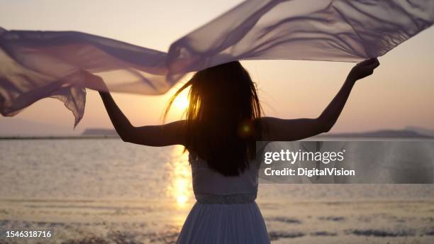 young woman waving silk in air - spirituality stock pictures, royalty-free photos & images