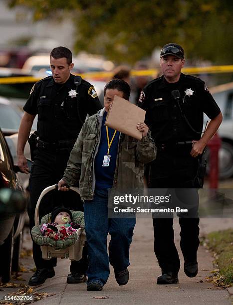 Member of child protection services carries an unharmed 6-month-old boy found at the scene of a triple homicide in a duplex in Rancho Cordova,...