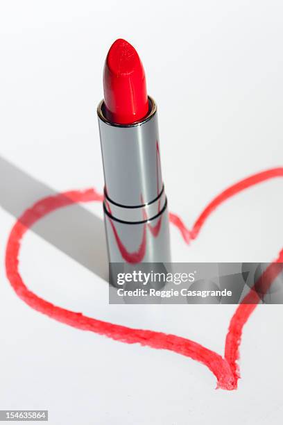 a lip-stick in a drawn heart shape on white - red lipstick stick stock pictures, royalty-free photos & images