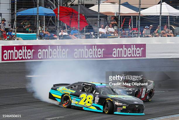 Kyle Sieg, driver of the Onsite Power Academy Ford, spins in front of Josh Berry, driver of the Jarrett Logistics Systems Chevrolet, after an...