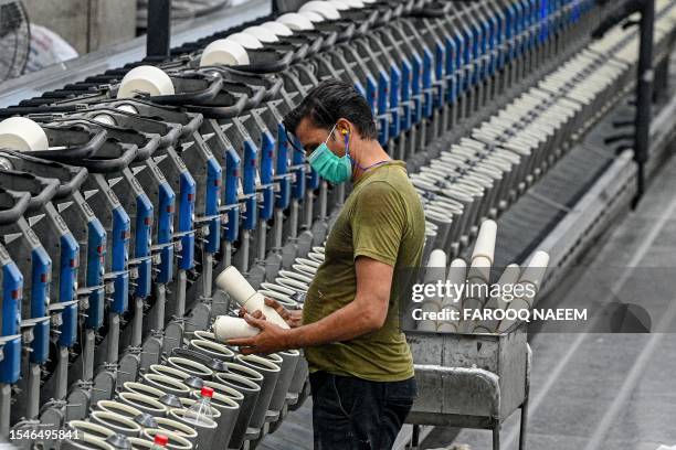 In this picture taken on July 20 a man works on a thread machine at the Kohinoor Textile Mills in Lahore.