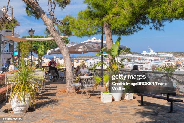 cafe at the viewpoint of lake voulismeni and the town, agios nikolaos, crete, greece, agios nikolaos, crete, greece - lake voulismeni stock pictures, royalty-free photos & images