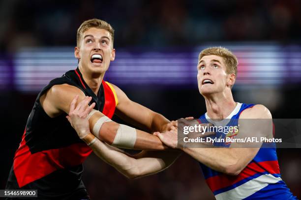 Nick Bryan of the Bombers and Tim English of the Bulldogs compete in a ruck contest during the 2023 AFL Round 19 match between the Essendon Bombers...