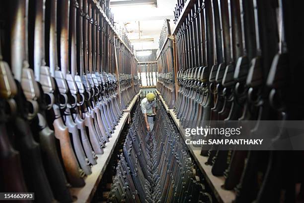 An Indian Homeguard serviceman performs a religious ritual over Lee-Enfield service rifles at an armoury during the Hindu festival of Dussehra in...