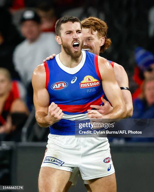 Marcus Bontempelli of the Bulldogs celebrates a goal with teammates Oskar Baker during the 2023 AFL Round 19 match between the Essendon Bombers and...