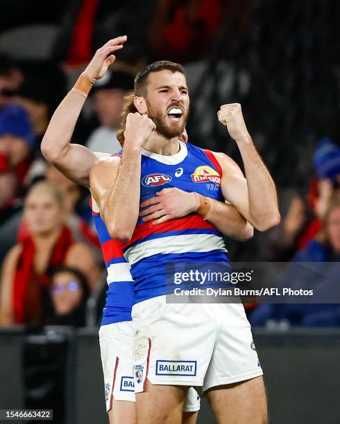 Marcus Bontempelli of the Bulldogs celebrates a goal with teammates Oskar Baker during the 2023 AFL Round 19 match between the Essendon Bombers and...