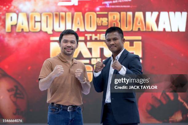 Filipino boxer Manny Pacquiao and Thai Muay Thai fighter Buakaw Banchamek pose for photographs during a press conference in Bangkok on July 21 to...