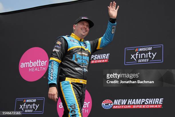 Brennan Poole, driver of the 511Auction.com Chevrolet, waves to fans as he walks onstage during driver intros prior to the NASCAR Xfinity Series...