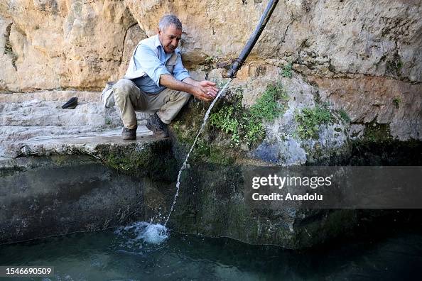 Ayn Spring A man sits near Ayn Al-Hawiyah spring, one of the water springs in ...