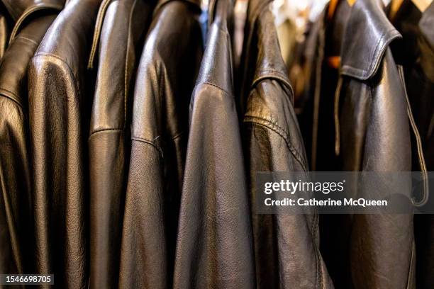rack of vintage black leather jackets at antique flea market - chaqueta de cuero fotografías e imágenes de stock