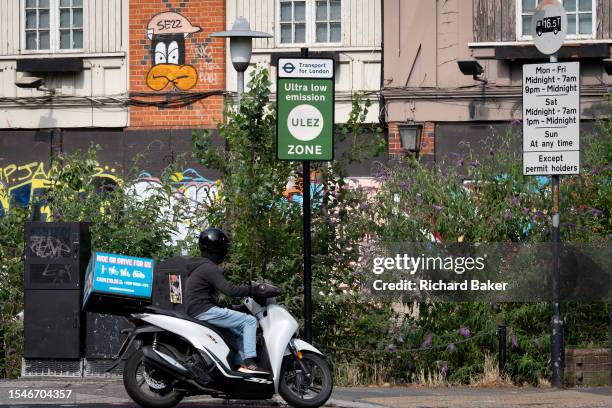 A moped scooter rider passers an ULEZ sign on the South Circular at East Dulwich, on 21st July 2023, in London, England. Introduced by his...