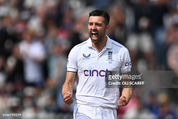 England's Mark Wood celebrates after taking the wicket of Australia's Usman Khawaja on day three of the fourth Ashes cricket Test match between...