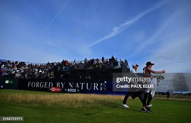 Golfer Stewart Cink walks with his caddie Lisa Cink as they leave the 17th green on day two of the 151st British Open Golf Championship at Royal...