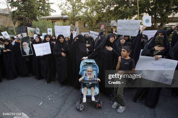 Iranian students lift placards and chant slogans during a demonstration denouncing the burning in Sweden of the Koran, Islam's holy book, in front of...