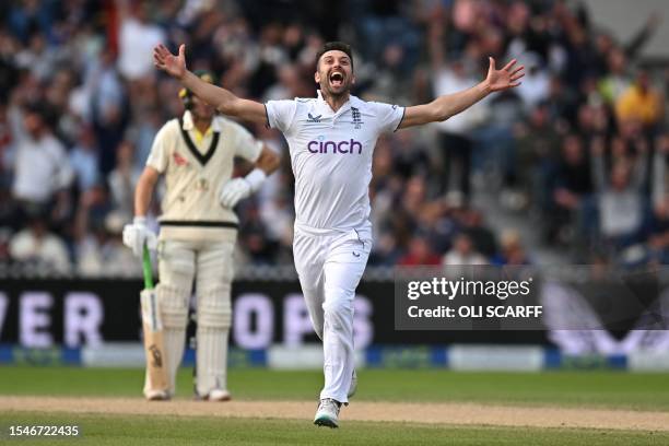 England's Mark Wood celebrates after taking the wicket of Australia's Travis Head on day three of the fourth Ashes cricket Test match between England...