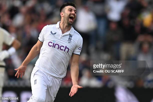 England's Mark Wood celebrates after taking the wicket of Australia's Travis Head on day three of the fourth Ashes cricket Test match between England...