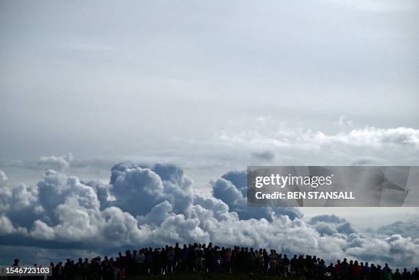 Spectators stand on a hill as they watch the play on the 12th green on day two of the 151st British Open Golf Championship at Royal Liverpool Golf...