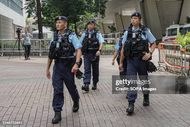 Police officers patrolling outside the court building. On July 21st Ronson Chan, a prominent Hong Kong journalist and Chairman of the Hong Kong...