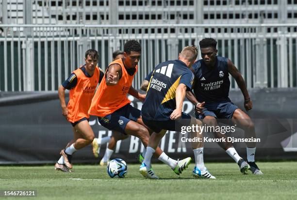 Jude Bellingham of Real Madrid controls the ball as he is defended by Toni Kroos and Aurélien Tchouaméni during training at UCLA Campus on July 21,...