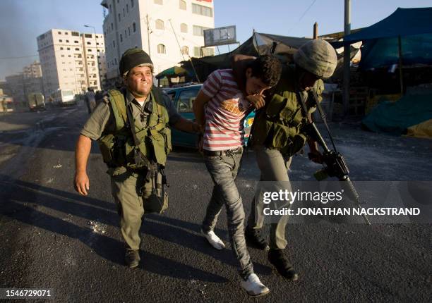 Israeli border policemen detain a Palestinian stone-throwing youth during clashes on October 5, 2009 in the east Jerusalem Shuafat refugee camp....