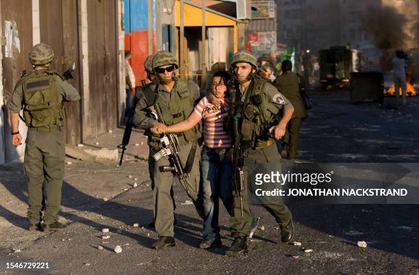Israeli border policemen detain a Palestinian stone-throwing youth during clashes on October 5, 2009 in the east Jerusalem Shuafat refugee camp....