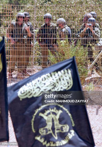 Israeli troops watch and take pictures as supporters of the Palestinian Islamic Jihad group demonstrate along the Lebanon-Israel border fence in the...